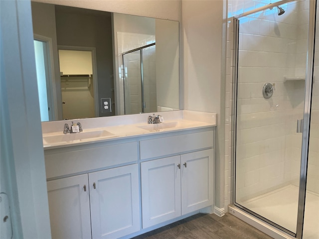 bathroom with vanity, a shower with shower door, and hardwood / wood-style flooring