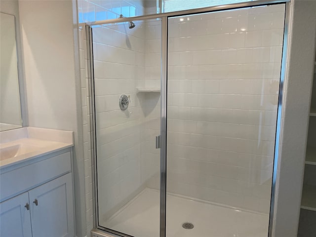 bathroom featuring vanity and a shower with door