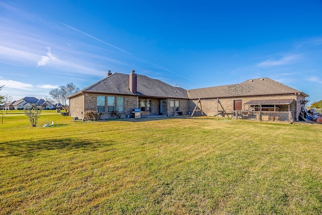 back of property with a yard and a patio