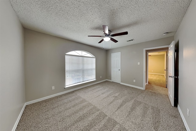 unfurnished bedroom featuring carpet flooring, ceiling fan, a textured ceiling, and a closet