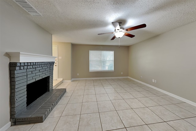 unfurnished living room with ceiling fan, a fireplace, light tile patterned flooring, and a textured ceiling