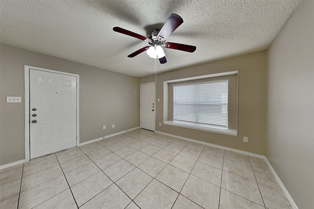 tiled empty room with a textured ceiling and ceiling fan