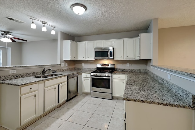 kitchen with kitchen peninsula, sink, white cabinets, and stainless steel appliances