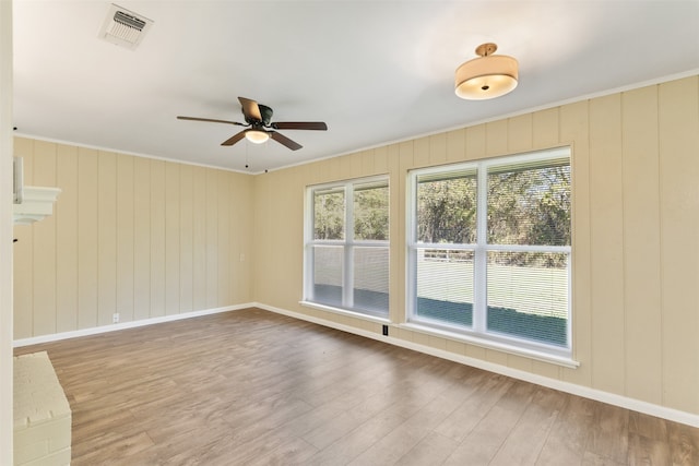 spare room featuring ceiling fan, wood-type flooring, and ornamental molding