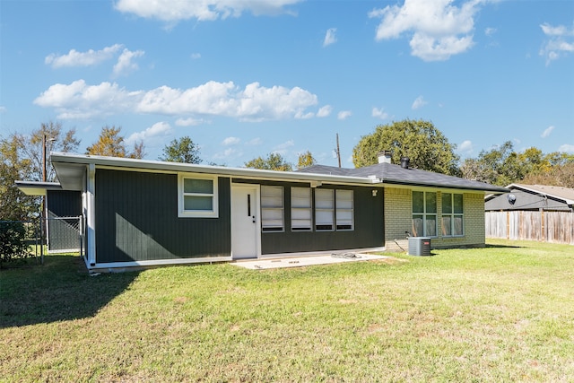 back of property featuring cooling unit and a lawn