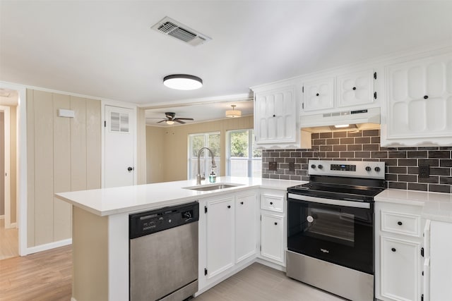 kitchen with premium range hood, kitchen peninsula, light wood-type flooring, appliances with stainless steel finishes, and white cabinetry