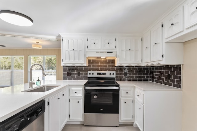 kitchen featuring backsplash, premium range hood, stainless steel appliances, sink, and white cabinets