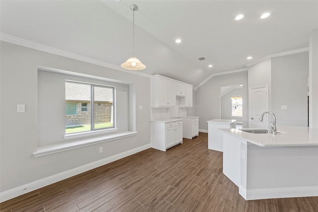 kitchen featuring an island with sink, wood-type flooring, sink, lofted ceiling, and white cabinets