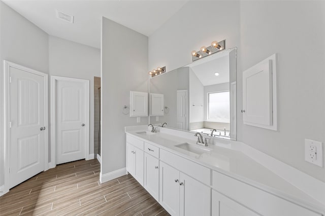 bathroom with vanity, a shower with shower door, and lofted ceiling