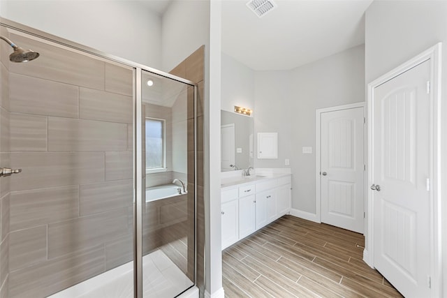 bathroom with vanity and shower with separate bathtub