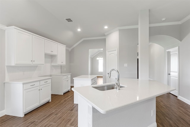 kitchen with sink, crown molding, hardwood / wood-style flooring, an island with sink, and white cabinets