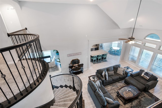 living room featuring ceiling fan, high vaulted ceiling, and light hardwood / wood-style floors