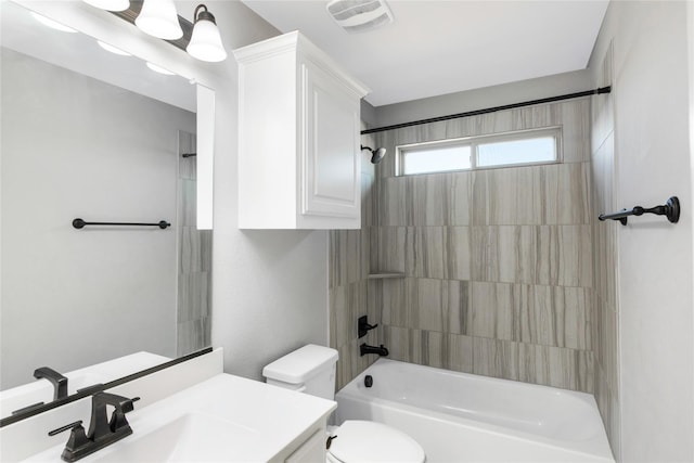 full bathroom featuring tiled shower / bath combo, toilet, and vanity