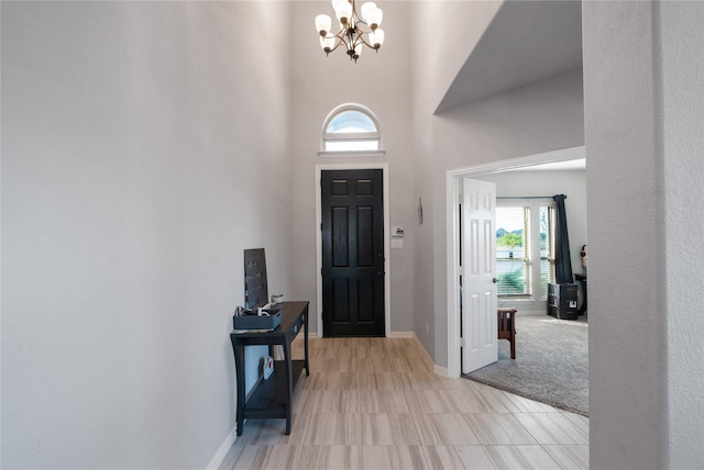 carpeted foyer entrance with a chandelier and a high ceiling