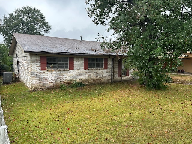 view of front of home with cooling unit and a front lawn