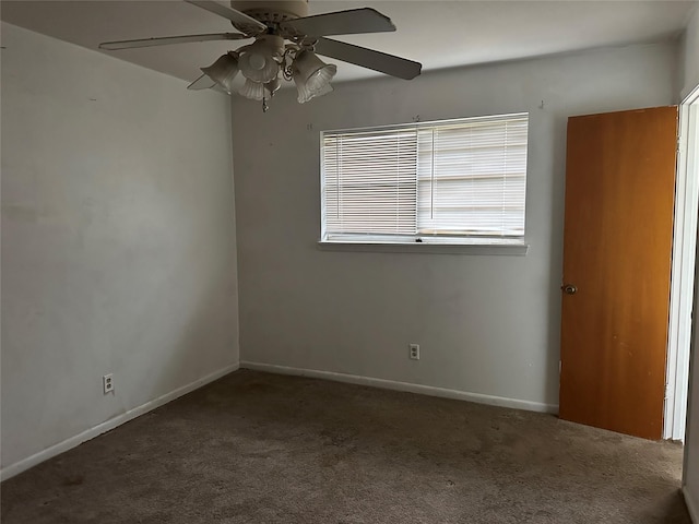 empty room with ceiling fan and dark colored carpet