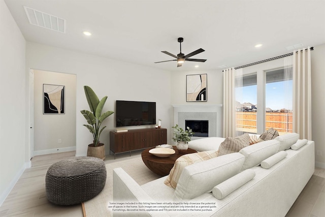 living room featuring ceiling fan and light hardwood / wood-style flooring