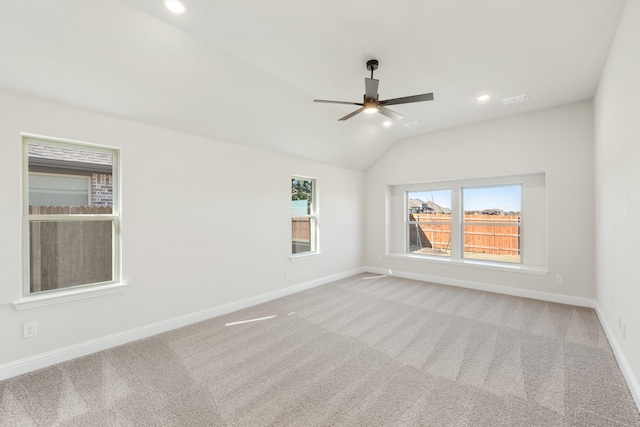 carpeted spare room featuring ceiling fan and vaulted ceiling