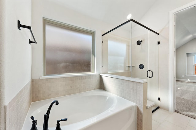 bathroom with tile patterned floors, shower with separate bathtub, and vaulted ceiling