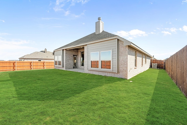 back of property with a lawn and central air condition unit