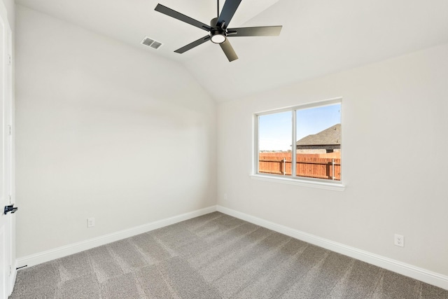 carpeted spare room with ceiling fan and vaulted ceiling