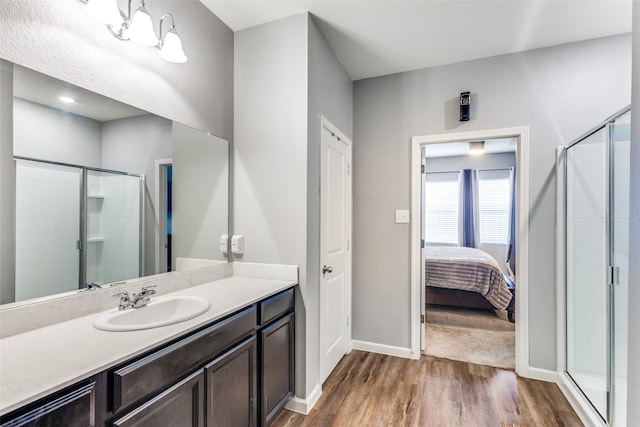 bathroom featuring hardwood / wood-style flooring, vanity, and a shower with shower door