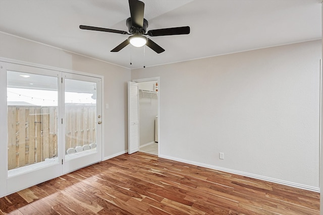 empty room with ceiling fan and hardwood / wood-style flooring