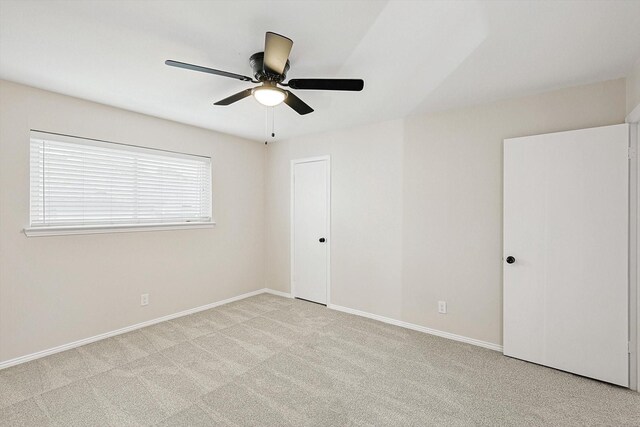 spare room featuring ceiling fan and light colored carpet