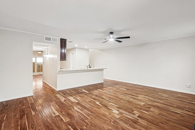 unfurnished living room with dark hardwood / wood-style floors, ceiling fan, sink, and crown molding