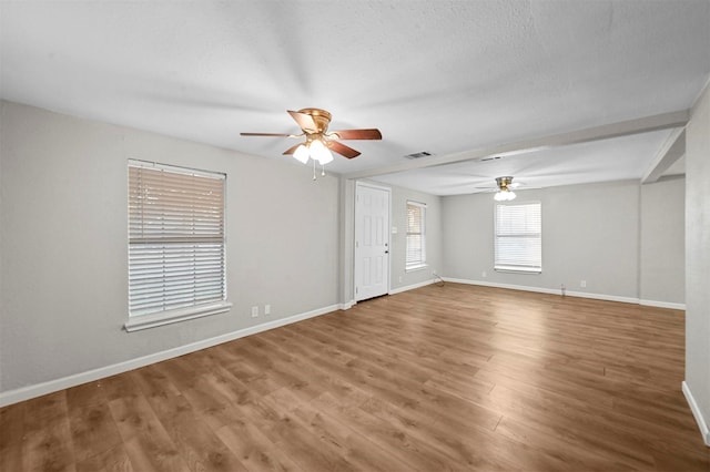 spare room with hardwood / wood-style floors, ceiling fan, and a textured ceiling