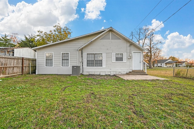 back of house featuring a patio, a yard, and central AC