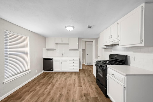 kitchen featuring sink, light hardwood / wood-style flooring, stainless steel dishwasher, white cabinetry, and black range with gas cooktop