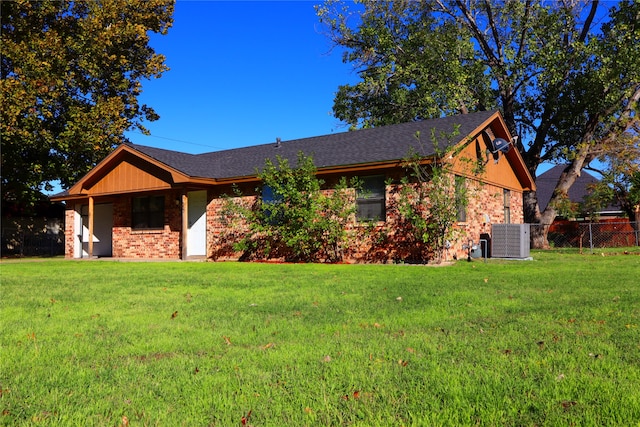 ranch-style home featuring central AC and a front yard