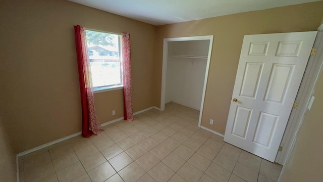 unfurnished bedroom with light tile patterned floors and a closet