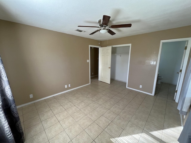 unfurnished bedroom featuring light tile patterned floors, a textured ceiling, a closet, and ceiling fan