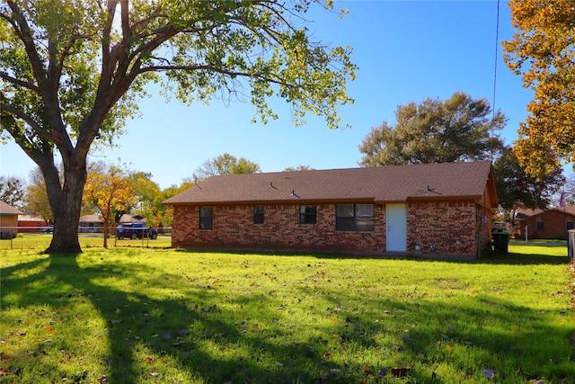 rear view of property featuring a yard