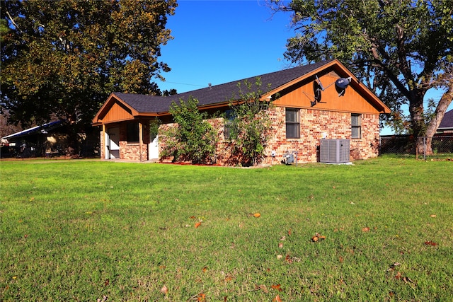 ranch-style home featuring central AC unit and a front lawn