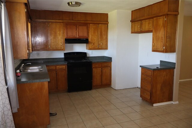 kitchen featuring light tile patterned floors, sink, and black / electric stove