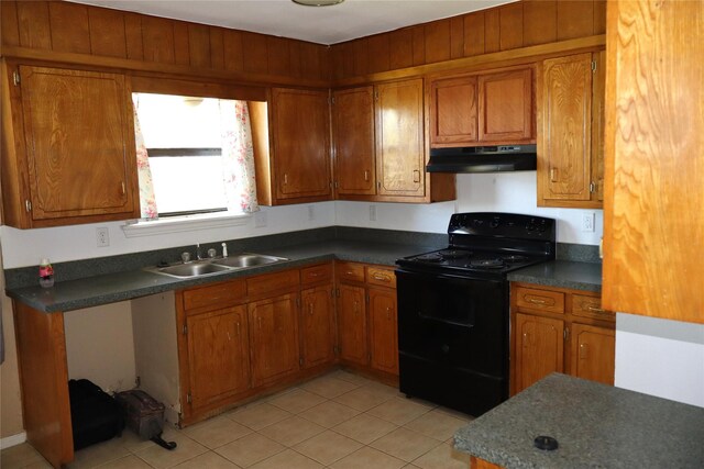 kitchen featuring black electric range, light tile patterned floors, and sink