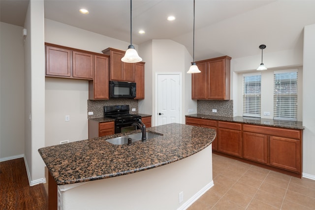 kitchen with decorative backsplash, decorative light fixtures, a kitchen island with sink, and black appliances