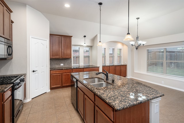 kitchen with sink, stainless steel appliances, a chandelier, decorative light fixtures, and a center island with sink