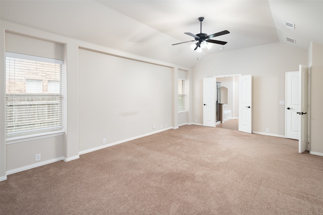 unfurnished bedroom featuring ceiling fan, light carpet, connected bathroom, and vaulted ceiling