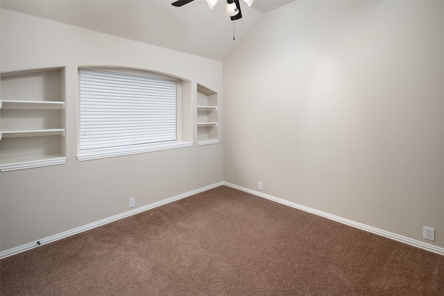 carpeted spare room featuring built in shelves, ceiling fan, and lofted ceiling