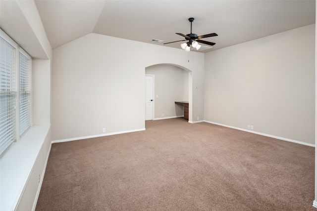 carpeted empty room featuring vaulted ceiling and ceiling fan