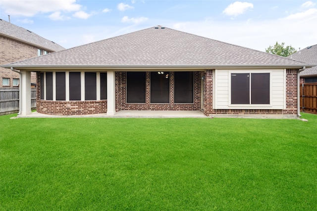 back of property with a yard and a sunroom