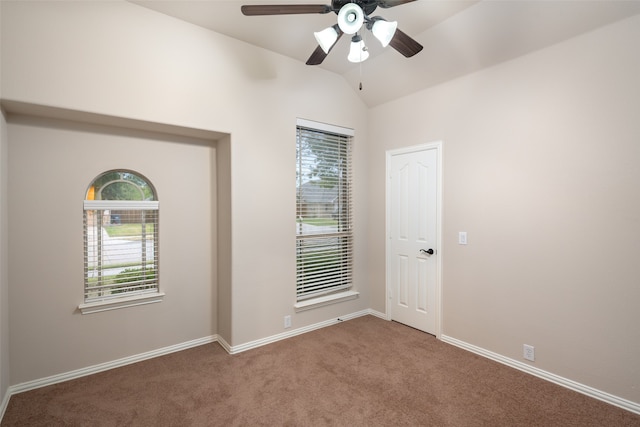 empty room featuring ceiling fan, carpet floors, and lofted ceiling