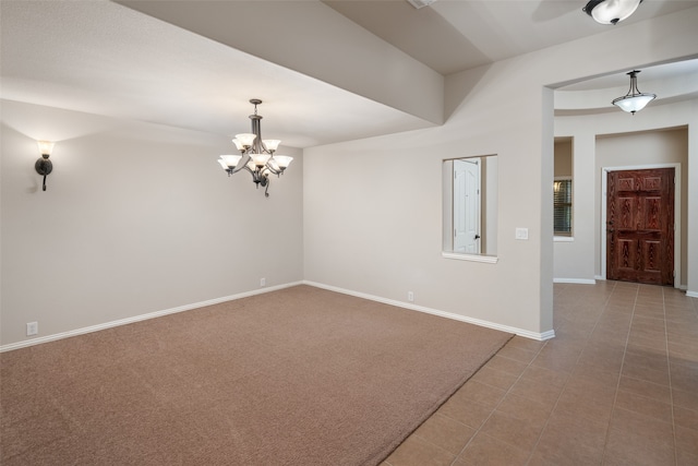 carpeted spare room with a notable chandelier