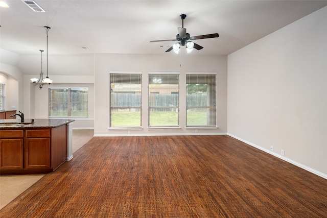 unfurnished living room with sink, wood-type flooring, and ceiling fan with notable chandelier