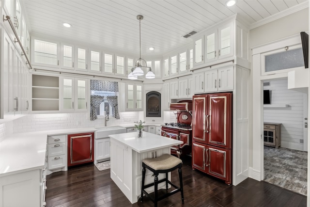 kitchen with white cabinetry, sink, paneled fridge, dark hardwood / wood-style flooring, and a kitchen island