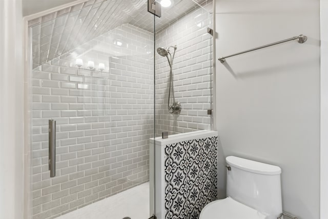 bathroom with a shower with door and toilet